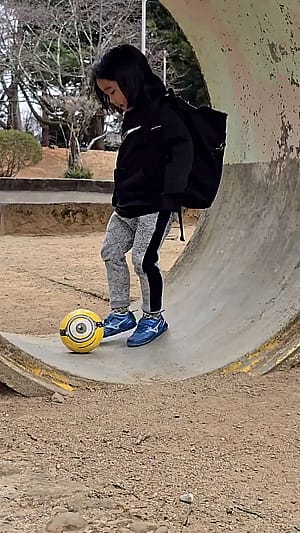 girl rolls the ball twice before landing in her bag'
